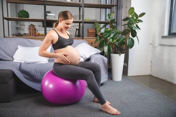 Mujer embarazada haciendo ejercicio en casa con pelota de fitness. rodaje en un estudio fotográfico — Foto de Stock