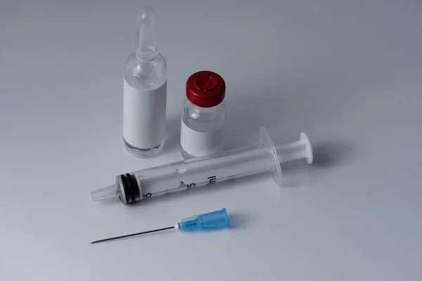 注射用の医療用バイアルと注射器灰色の背景 — ストック写真