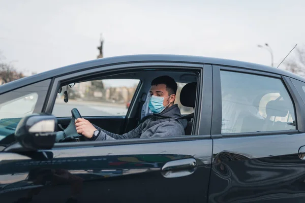 Hombre Que Conduce Coche Pone Una Máscara Médica Durante Una Imagen de archivo