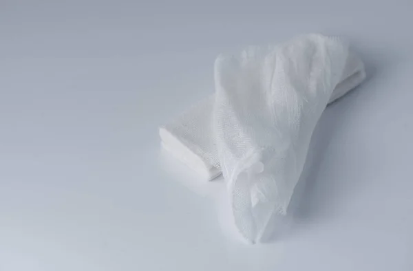 グレーの背景に白い医療綿ガーゼ包帯 新しい応急処置ガーゼ展開の医療包帯 — ストック写真
