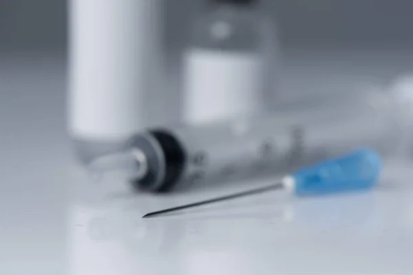 Beyaz arka planda iğne ve şırınga için tıbbi şişeler.