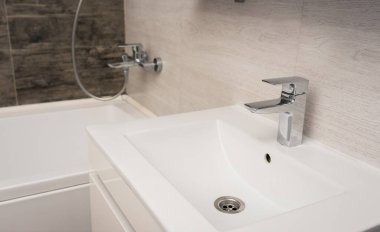 Banyoda beyaz lavabo, el dezenfeksiyonu, halı 19, dezenfektan, sabun ve musluk.