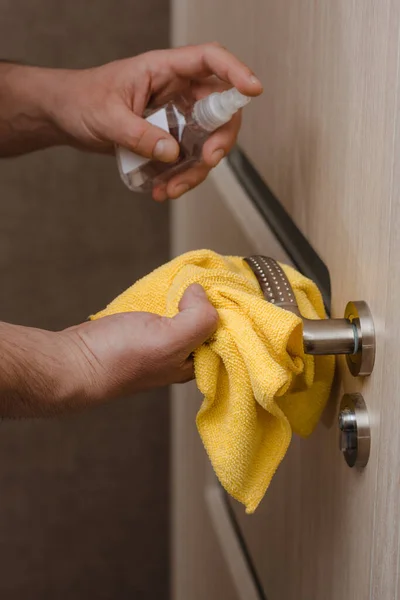 Virüs salgını sırasında temizlik kapısı antiseptikle açılıyor. Bakteriyel ıslak mendil kullanarak bir ev kapısını dezenfekte eden bir adamın yakın görüntüsü. covid 19, koronavirüs
