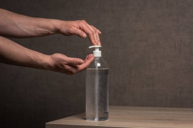 El dezenfektanı alkollü jel, temiz elleri ovuşturur. Koronavirüs salgınını önler. Bir şişe antibakteriyel sabun kullanan adam. Coronavirüs, covid 19.
