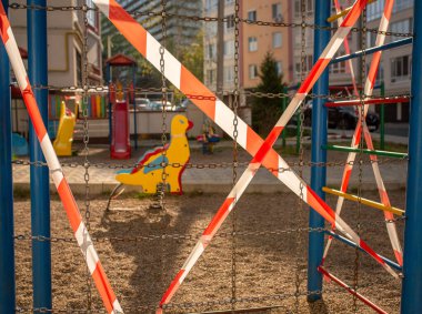 Çizgili kırmızı bantla sarılı oyun parkı, evde kal. Spor için karantina alanı, covid-19 coronavirus gribi enfeksiyonunun önlenmesi