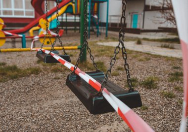 Çizgili kırmızı bantla sarılı oyun parkı, evde kal. Spor için karantina alanı, covid-19 coronavirus gribi virüsünü önleme. Kimse yok.