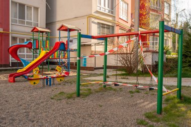 Çizgili kırmızı bantla sarılı oyun parkı, evde kal. Spor için karantina alanı, covid-19 coronavirus gribi enfeksiyonunun önlenmesi
