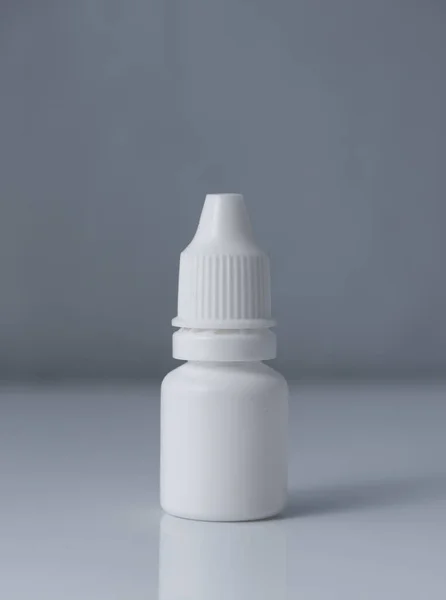 White plastic medical container on white, gray background
