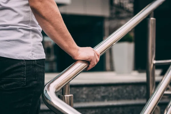 Korkuluktaki adam, beyaz tişörtlü ve siyah kotlu bir adam. Yukarı çık. dışarıName