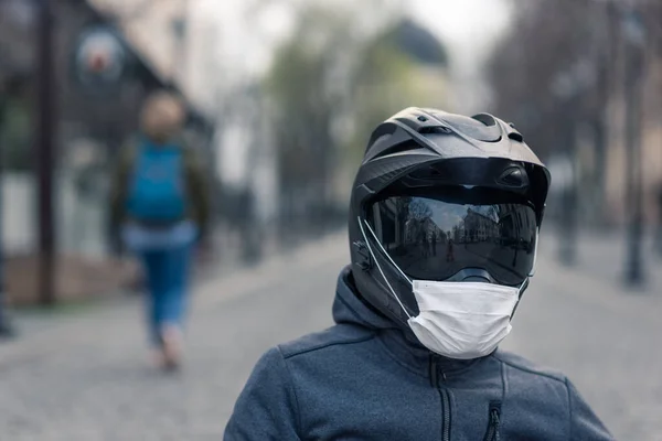 헬멧을 남자의 초상화 오토바이 헬멧에 마스크를 집들의 뒷골목에서 사진입니다 코로나 — 스톡 사진