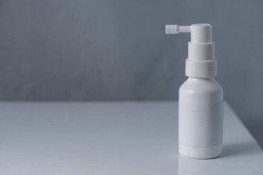 Eczane. Beyaz arka planda izole edilmiş beyaz şişedeki boğaz spreyi. tıbbi konteynır