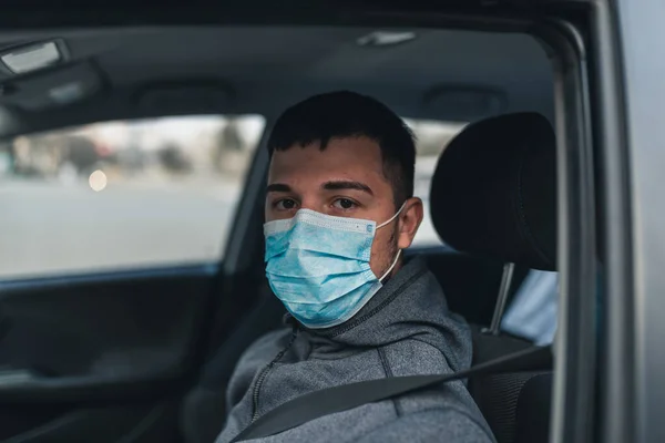 Hombre Que Conduce Coche Pone Una Máscara Médica Durante Una Imagen de stock