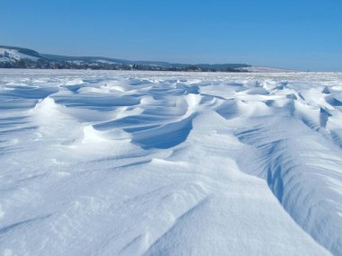 Kış arazisi ve karlı yol manzarası. Mavi gökyüzü ve kış yolu. Ternopil 'deki Willow köyünün yakınındaki karlı tarlada. Batı Ukrayna 'daki Karpat Dağlarının Kış Doğası.