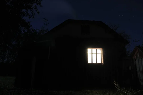 House on night sky background. Window with light. Background wth shining window for phones and tablets.