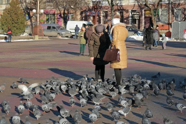 Dwie Młode Dziewczyny Karmią Gołębie Rynku Zimowy Słoneczny Dzień Centralnym — Zdjęcie stockowe