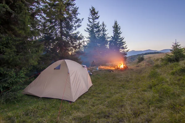 Pěší turisté stan v horách na večer táborák s jiskří — Stock fotografie