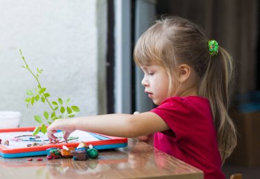 Küçük sevimli kız oyun tablo oynamak dışında