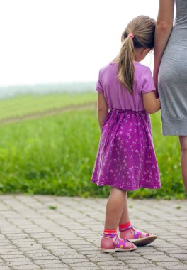 Küçük kız annesinin elini tutuyor. Aile ilişkileri conce