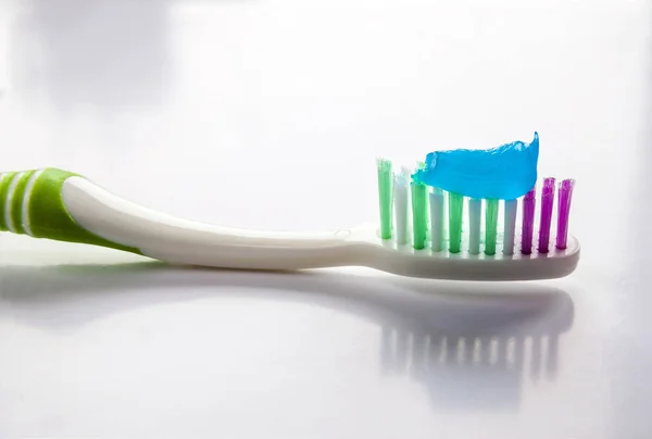 Toothpaste on a toothbrush close-up on a white light background — Stock Photo, Image