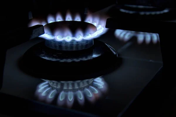 Brennende Gasherdplatten Blaue Flammen in der Dunkelheit auf einem blac — Stockfoto