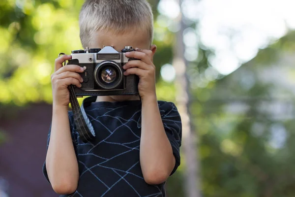 Lindo niño feliz con cámara de fotos vintage al aire libre — Foto de Stock