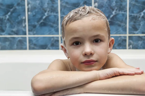 Очаровательный мальчик с шампунем и мылом на волосах, принимающих ванну. Cl — стоковое фото
