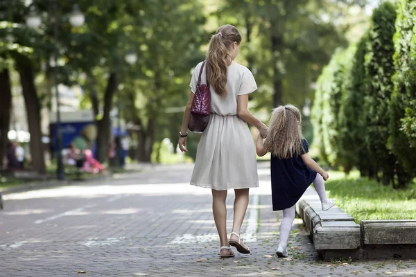 에 작은 여 자가 딸과 함께 산책 하는 젊은 어머니의 뒷 모습 — 스톡 사진