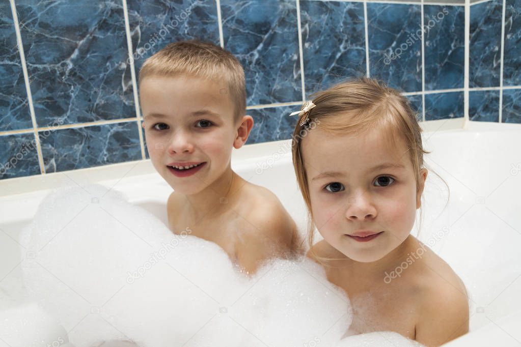Brother and sister taking a bubble bath. Little boy and 