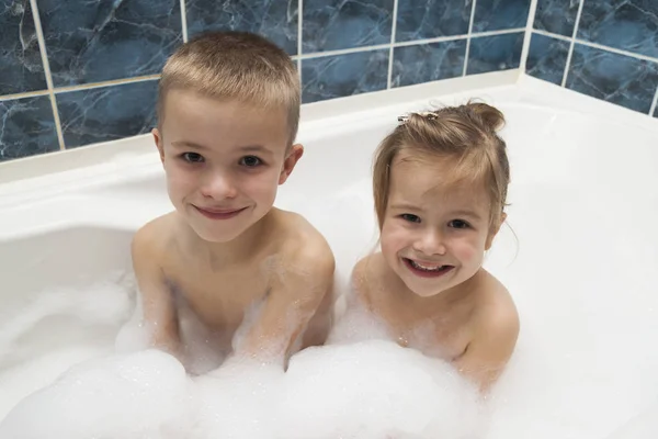 Brother and sister taking a bubble bath. Little boy and 