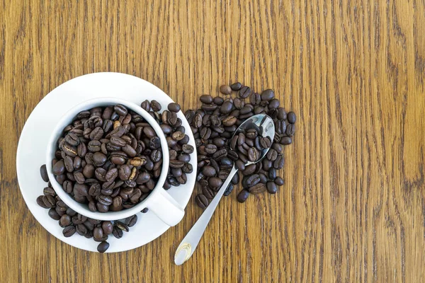 Tazza di caffè in una tazza bianca e chicchi di caffè su tavolo di legno ba — Foto Stock