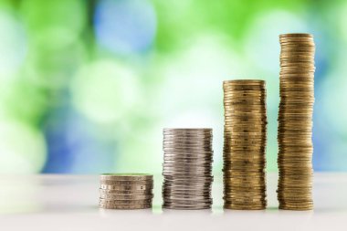 Paralar yığınlar yeşil ve mavi parlak bokeh backgro ile büyüyen