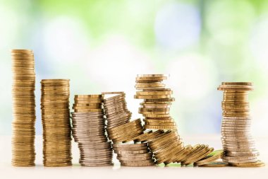 Paralar yığınlar yeşil ve mavi parlak bokeh backgro ile büyüyen