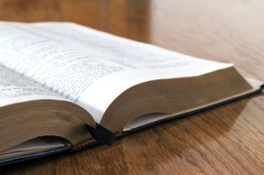 Sarı ahşap arka plan üzerine açık kitap İncil'de