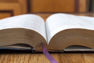 Sarı ahşap arka plan üzerine açık kitap İncil'de
