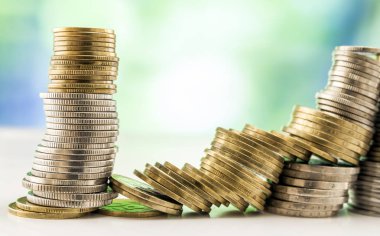 Paralar yığınlar yeşil ve mavi parlak bokeh backgro ile büyüyen