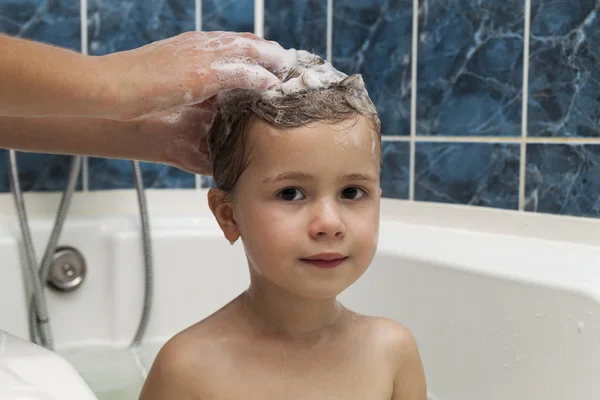 Мамины руки, моющие голову маленькой девчушки в ванной. Сим — стоковое фото