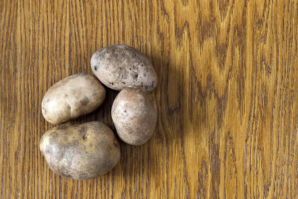 Raw potato food . Potatoes on a wooden table . Free space for te