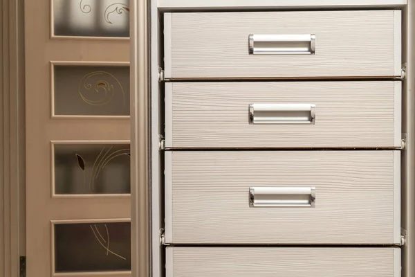 Detail of wooden furniture cabinet chest with drawers front, met