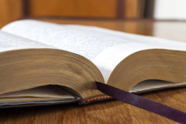 Sarı ahşap arka plan üzerine açık kitap İncil'de
