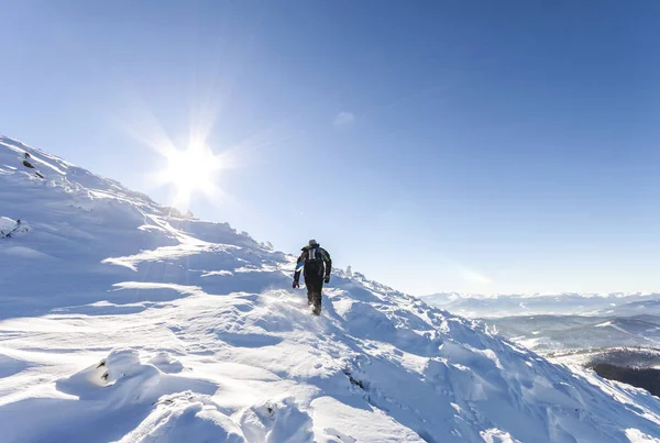 Un montañero macho caminando cuesta arriba sobre un glaciar. Alcance del montañero —  Fotos de Stock