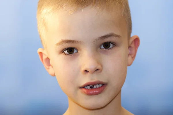 Gros plan du garçon souriant avec une dent de lait avant manquante sur la lumière — Photo