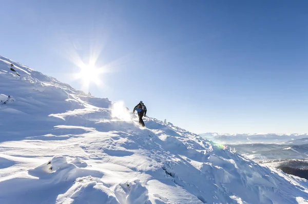 Un montañero macho caminando cuesta arriba sobre un glaciar. Alcance del montañero —  Fotos de Stock