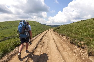 Yaz güneşli bir günde Dağa tırmanma uzun yürüyüşe çıkan kimse