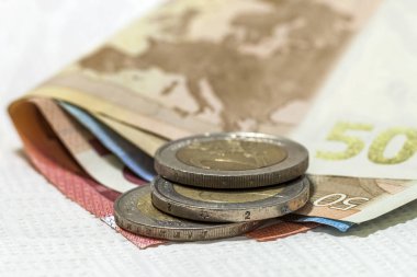 Para euro sikke ve banknot birbirlerine farklı pozisyonlarda yığılmış. Para kavramı. Euro para masanın üstüne detay