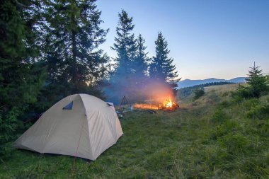 Yürüyüşçüler çadır Dağları ile bir şenlik ateşi ile akşam parıldıyor