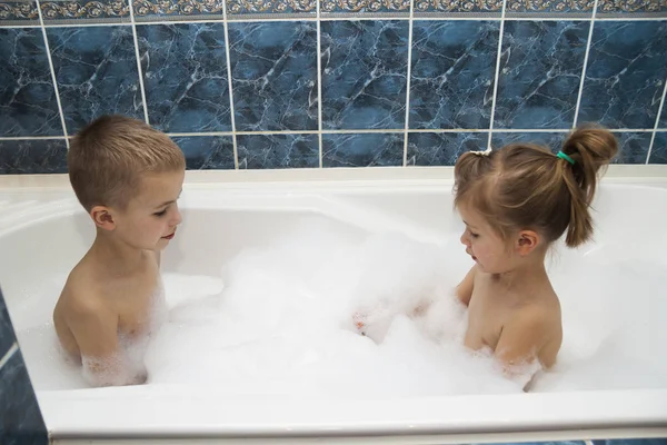 Irmão e irmã, tomando um banho de espuma. Pla de menino e 