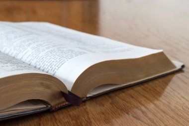 Sarı ahşap arka plan üzerine açık kitap İncil'de