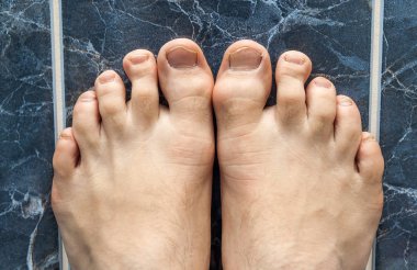 Genç kare fayans geçiş ayakta adam. Damar feet görünür.