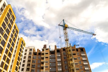 Vinç ve yüksek doğmak inşaat mavi gökyüzü altında bina