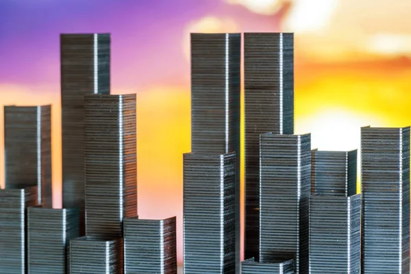 Staples arranged to form city skyline on a sunset background — Stock Photo, Image